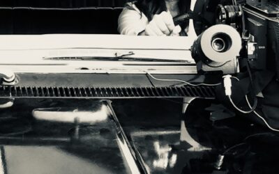A behind the camera production shot of a beaten up Sarah-Jane Redmond, behind the wheel of 'Baby' on TV series Supernatural.